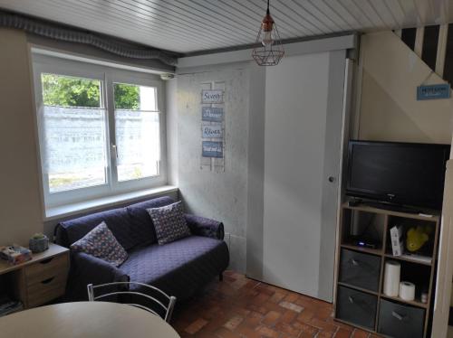 ein Wohnzimmer mit Sofa und Fernseher in der Unterkunft ty anna in Le Palais