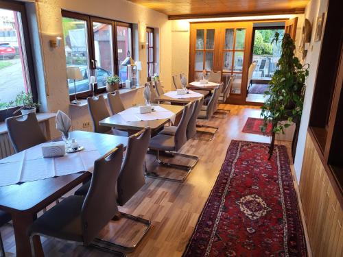a restaurant with wooden tables and chairs and a rug at Hotel Schönblick in Bad Herrenalb