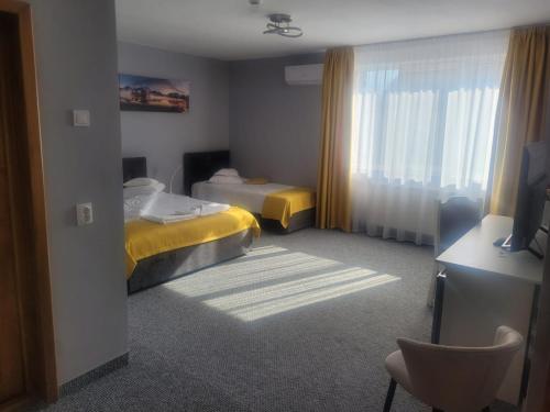 a hotel room with two beds and a chair at Hotel Delaf in Cluj-Napoca