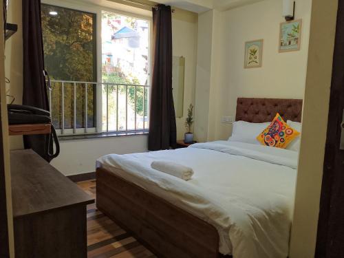 a bedroom with a large bed and a window at Darjeeling Hillside Inn in Jālāpahār