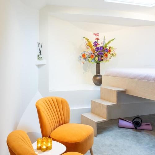 a bedroom with a bed and a chair and a table at Boat suite - A Unique Houseboat Stay in Amsterdam in Amsterdam