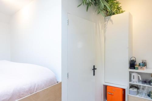 a bedroom with a bed and a white cabinet at Boat suite - A Unique Houseboat Stay in Amsterdam in Amsterdam