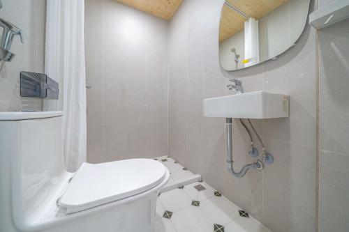 a white bathroom with a toilet and a sink at Nantuju in Ch'ih-k'an-lou