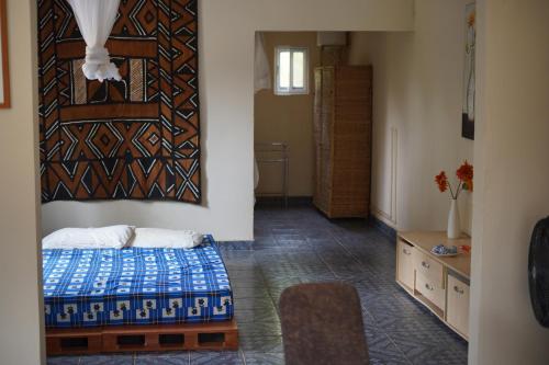 a bedroom with a bed and a painting on the wall at Dafa Tanga Lodge in Sanyang