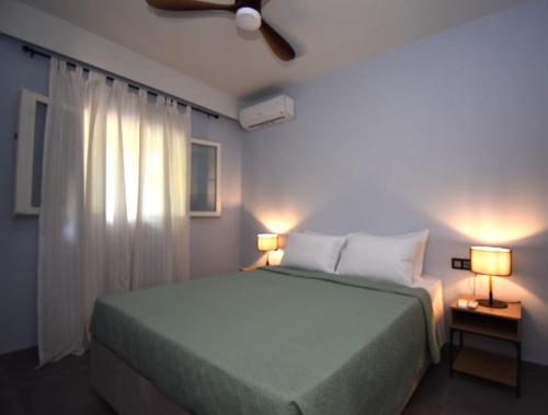 a bedroom with a large bed and two lamps at Casa Campagnolo in Corfu
