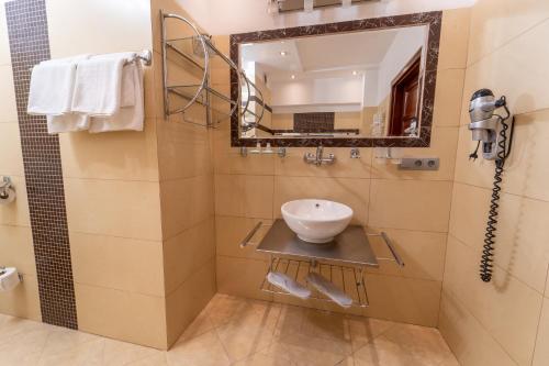 a bathroom with a sink and a mirror at Hotel Polski in Mielec