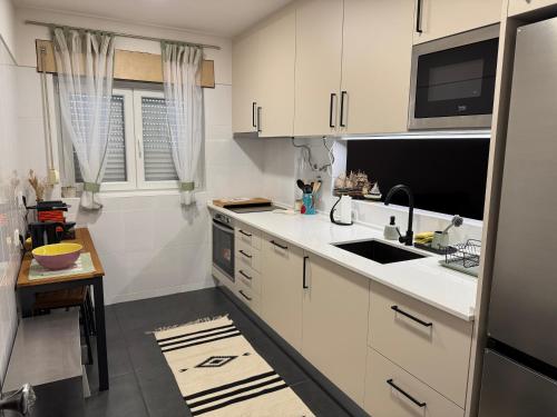 a kitchen with white cabinets and a sink at Apartamento Santa Cruz in Santa Cruz