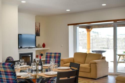 a dining room with a table and a couch at Feel Discovery Quinta do Muro Douro Valley in Peso da Régua