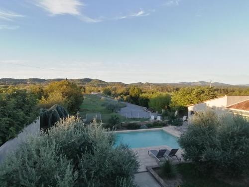 une vue sur une piscine avec des chaises et des arbres dans l'établissement gite entre mer et montagne, à Savignargues