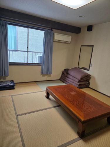 a room with a bed and a table in it at business hotel furusatoビジネスホテルふるさと in Ureshino