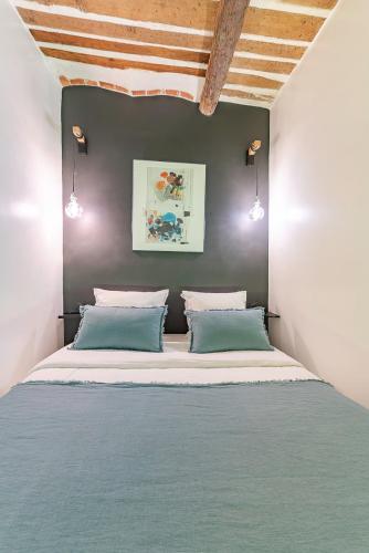 une chambre avec un grand lit avec des oreillers bleus dans l'établissement Belle rénovation moderne au coeur du Panier, à Marseille