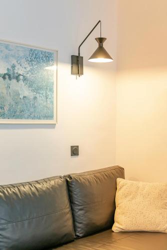 un canapé en cuir brun dans une pièce avec un tableau dans l'établissement Belle rénovation moderne au coeur du Panier, à Marseille
