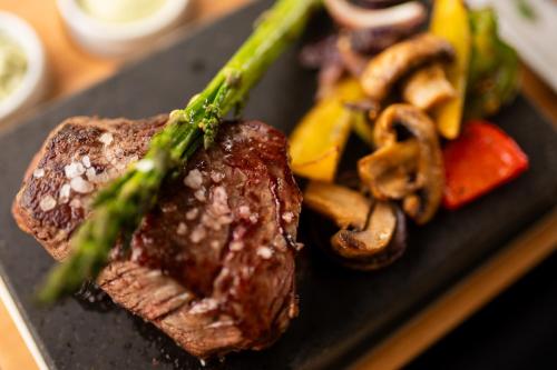 a plate of food with steak and vegetables on it at Hotel Igloo in Krotoszyn