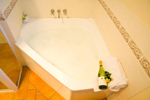 uma banheira branca com uma garrafa de champanhe em Starlight Motor Inn em Roma