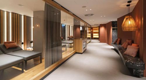 a hallway of a hotel with a couch and chairs at ATLANTIC Hotel Münster in Münster