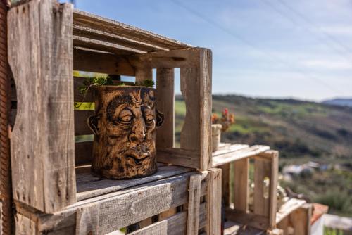 a wooden box with a statue of a head on it at Finca Gran Cerros in Alora