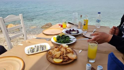 a table with food and drinks on a table by the water at Studio Xanthippe in Kalamos