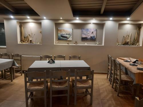 a dining room with tables and chairs and paintings on the wall at Studio Xanthippe in Kalamos