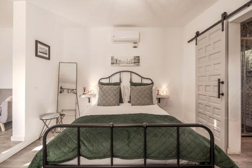 a bedroom with a bed with a green bedspread at Finca Gran Cerros in Alora