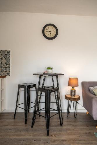 a table with two stools and a clock on a wall at Finca Gran Cerros in Alora