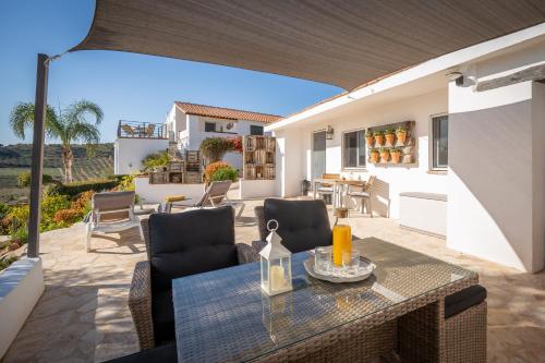 a patio with a table and chairs on a balcony at Finca Gran Cerros in Alora
