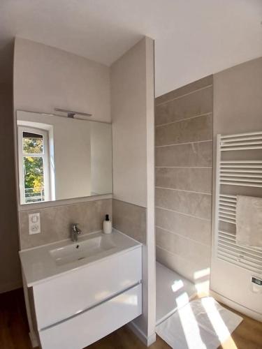 a white bathroom with a sink and a window at Appart centre-ville proche gare in Feurs