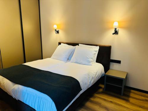 a bedroom with a bed with white sheets and pillows at Longstay Achterhoek in Zeddam