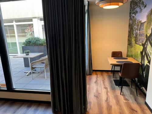 a room with a table and chairs and a window at Longstay Achterhoek in Zeddam