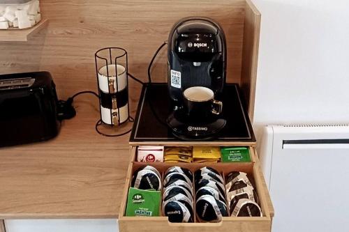 a box of donuts and a coffee maker on a counter at Maison l'Olivier in Nevers