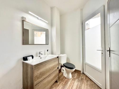 een badkamer met een wastafel, een toilet en een spiegel bij Le Cocon Urbain - Spacieux - Hyper Centre in Mont-de-Marsan
