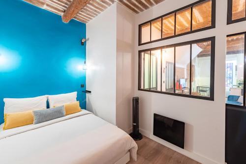 une chambre avec un lit blanc et une télévision dans l'établissement T1 pop tout neuf au Panier, à Marseille