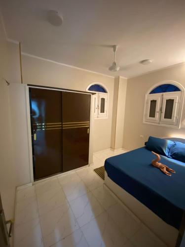a bedroom with a blue bed and a sliding glass door at SmSm Kato in Aswan