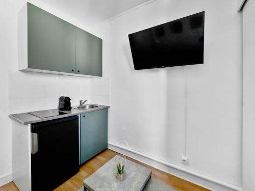 - une cuisine avec un évier et une table dans une chambre dans l'établissement Studio Cosy 2P Face Arc De Triomphe, à Paris