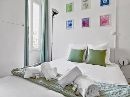 - une chambre blanche avec des serviettes sur un lit dans l'établissement Studio Cosy 2P Face Arc De Triomphe, à Paris