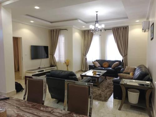 a living room with leather furniture and a television at Unit 1 apartments in Abuja