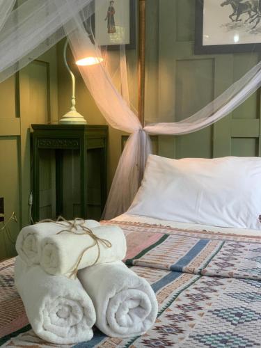 a bedroom with a bed with towels on it at Mintys Folly 2 in Ban Man