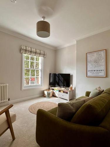 a living room with a couch and a flat screen tv at Charming Townhouse Retreat in Shrewsbury