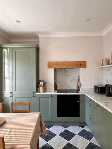 a kitchen with blue cabinets and a checkered floor at Charming Townhouse Retreat in Shrewsbury