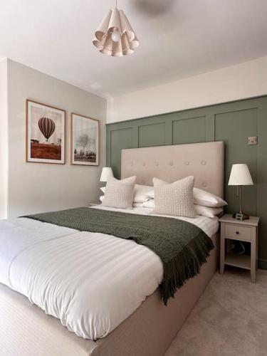Un dormitorio con una cama grande con almohadas blancas. en Charming Townhouse Retreat, en Shrewsbury