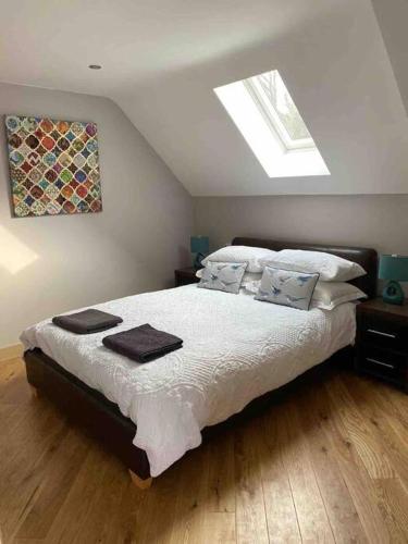 a bedroom with a bed with white sheets and pillows at A space with amazing views and alpacas to enjoy in Chewton Mendip