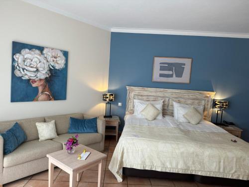 a bedroom with a bed and a couch at Boutique Hotel Vivenda Miranda in Lagos