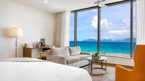 a hotel room with a bed and a chair and a large window at Aurora Anguilla Resort & Golf Club in Rendezvous Beach
