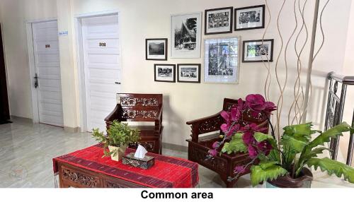 a room with a table and a chair and pictures on the wall at Zoé’s Paradise Waterfront Hotel in Tuk Tuk