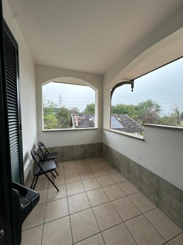 a room with two windows and a tiled floor at Affittacamere Karma Rho-Fiera in Rho