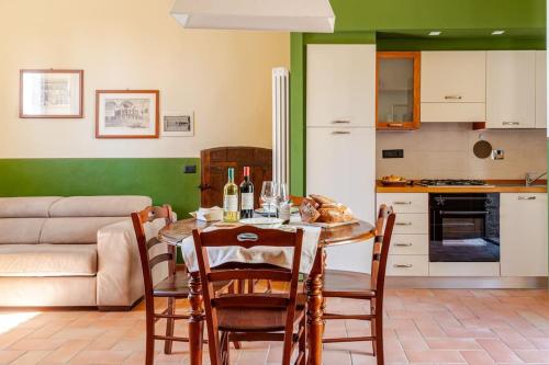 a kitchen with a table with chairs and a couch at Agriturismo La Torre dell'Oliveto in Agello