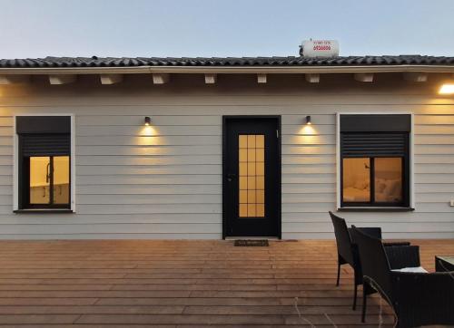 a white house with two windows and a patio at LanGo in Yonatan