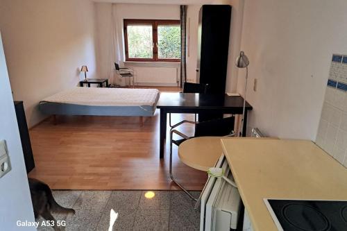 Una pequeña habitación con una cama y un escritorio. en Zentrale Messewohnung im wunderschönen Vorort, en Eschborn