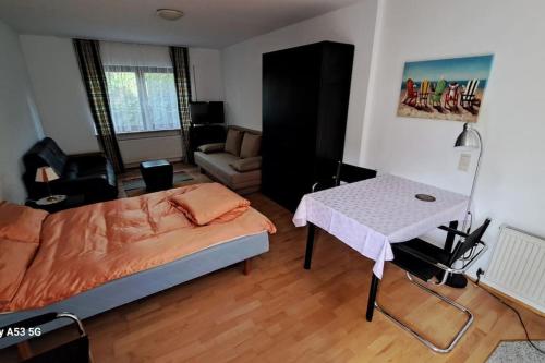 Un dormitorio con una cama, una mesa y un sofá. en Zentrale Messewohnung im wunderschönen Vorort, en Eschborn