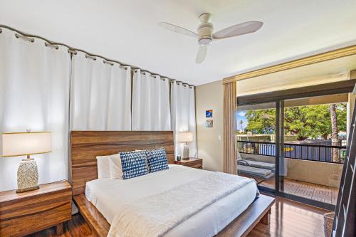 a bedroom with a large bed and a balcony at Kaanapali Royal Q-202 in Lahaina