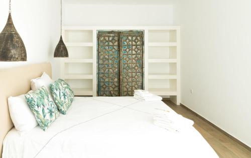 a bedroom with a white bed with white shelves at Shangri-La in Meganisi